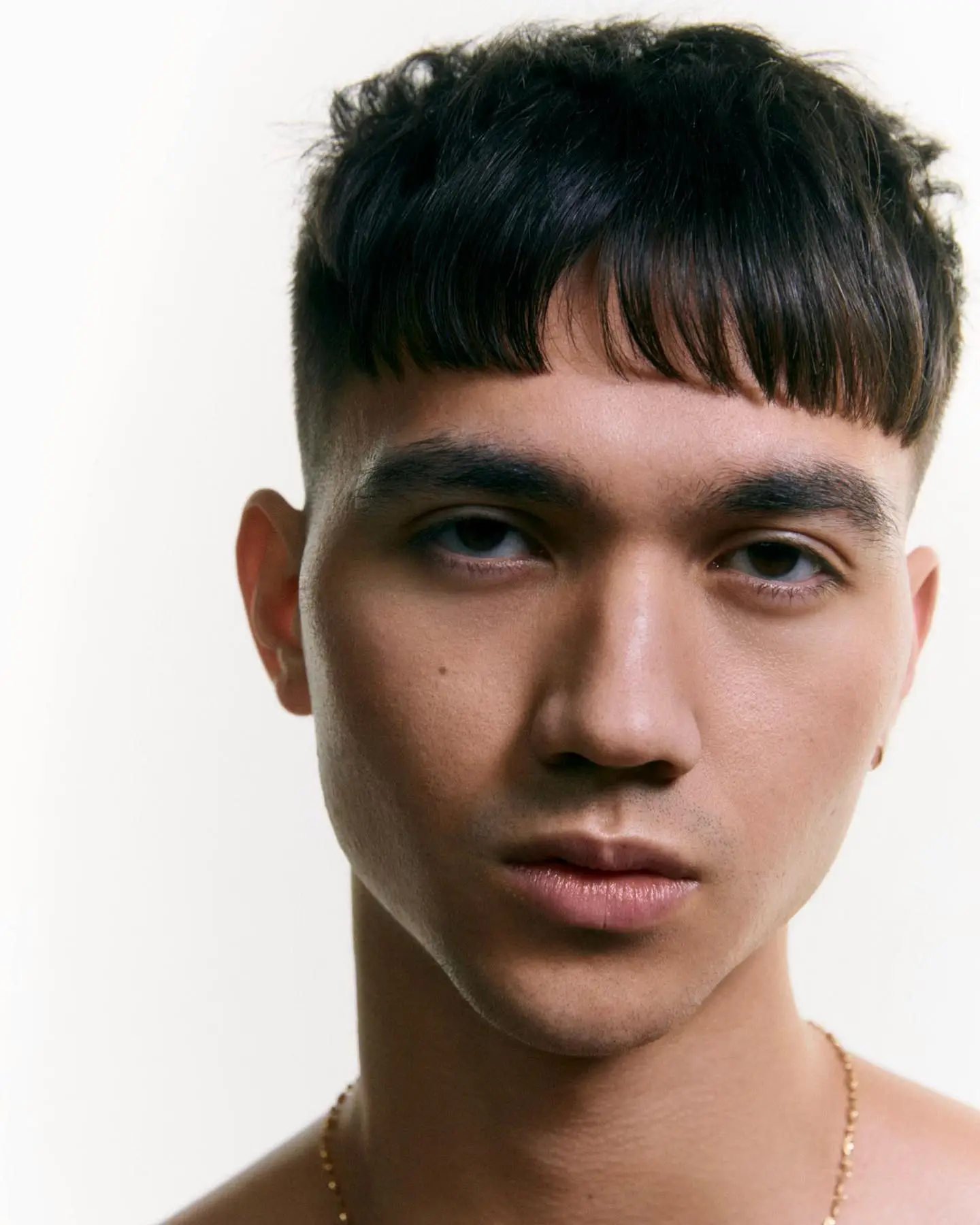 Frizura s temple fade prehodom in top frufrujem za diamantno obliko obraza.