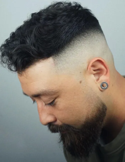 Moška frizura s skin fade prehodom, primerna za okrogel obraz.