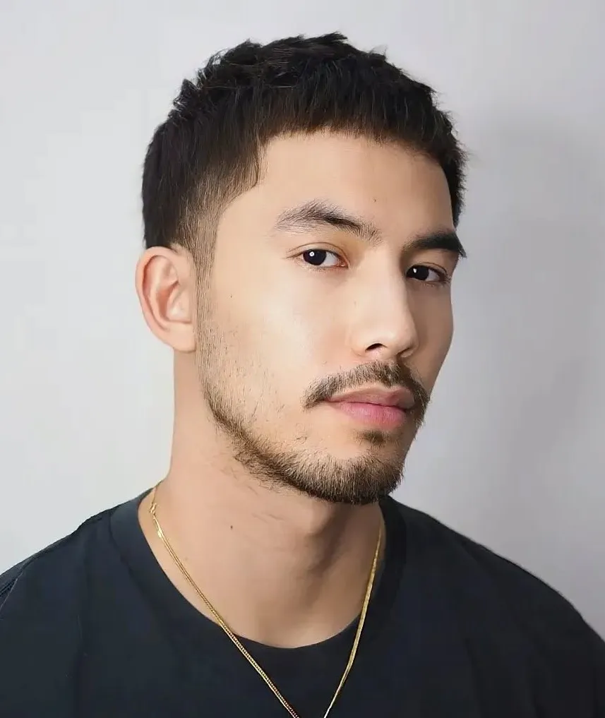 Kratka buzz frizura, ki poudari poteze ovalnega obraza.