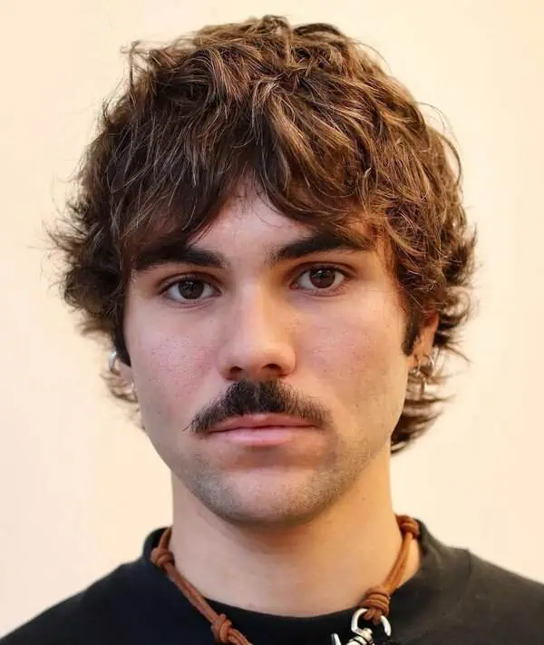 Moška frizura textured shag z mehko teksturo in sproščenimi prameni, primerna za srčasto obliko obraza.